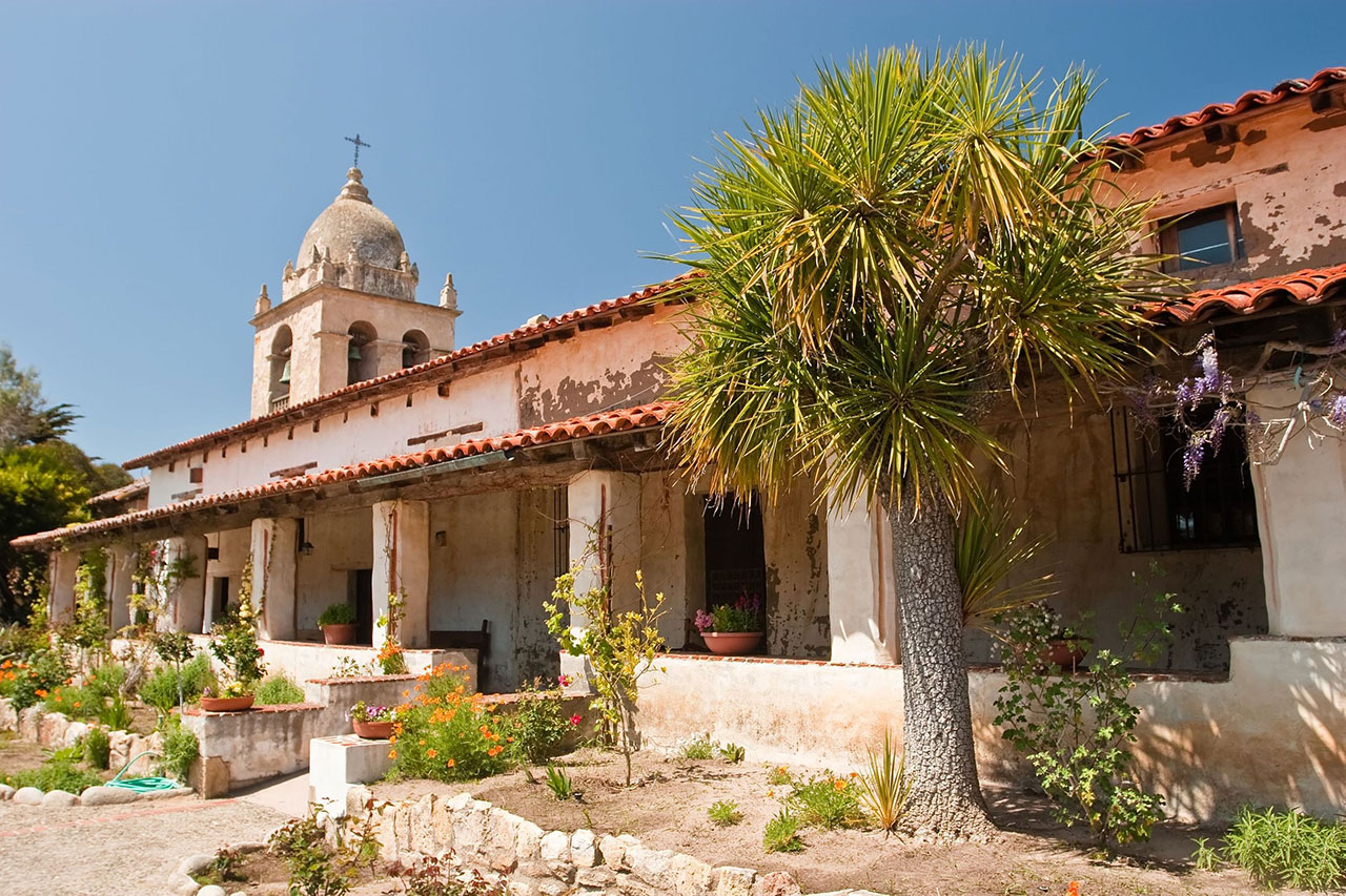 Garden and walkway with view of the belltower at Carmel Mission.