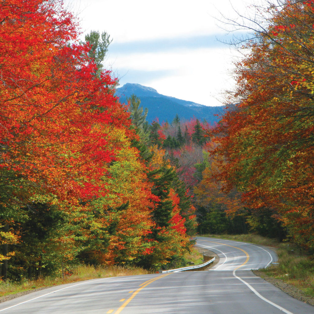 The Kancamagus Highway winding between fall foliage.
