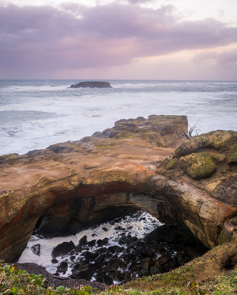 The Devil's Punchbowl rock formation with water swirling into a circular chamber.