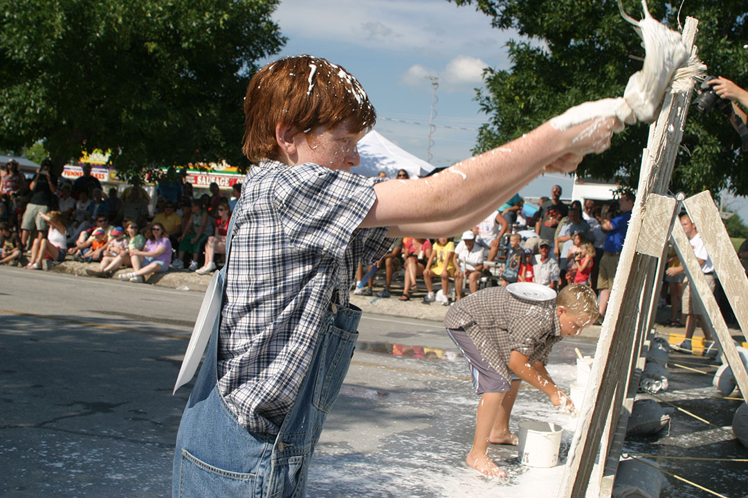 A boy participates in the fence whitewashing contest at Hannibal's Tom Sawyer Days Festival