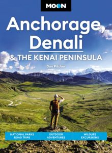 Cover of the Moon Anchorage, Denali, and the Kenai Peninsula travel guide featuring an image of a hiker overlooking a bright green mountain valley