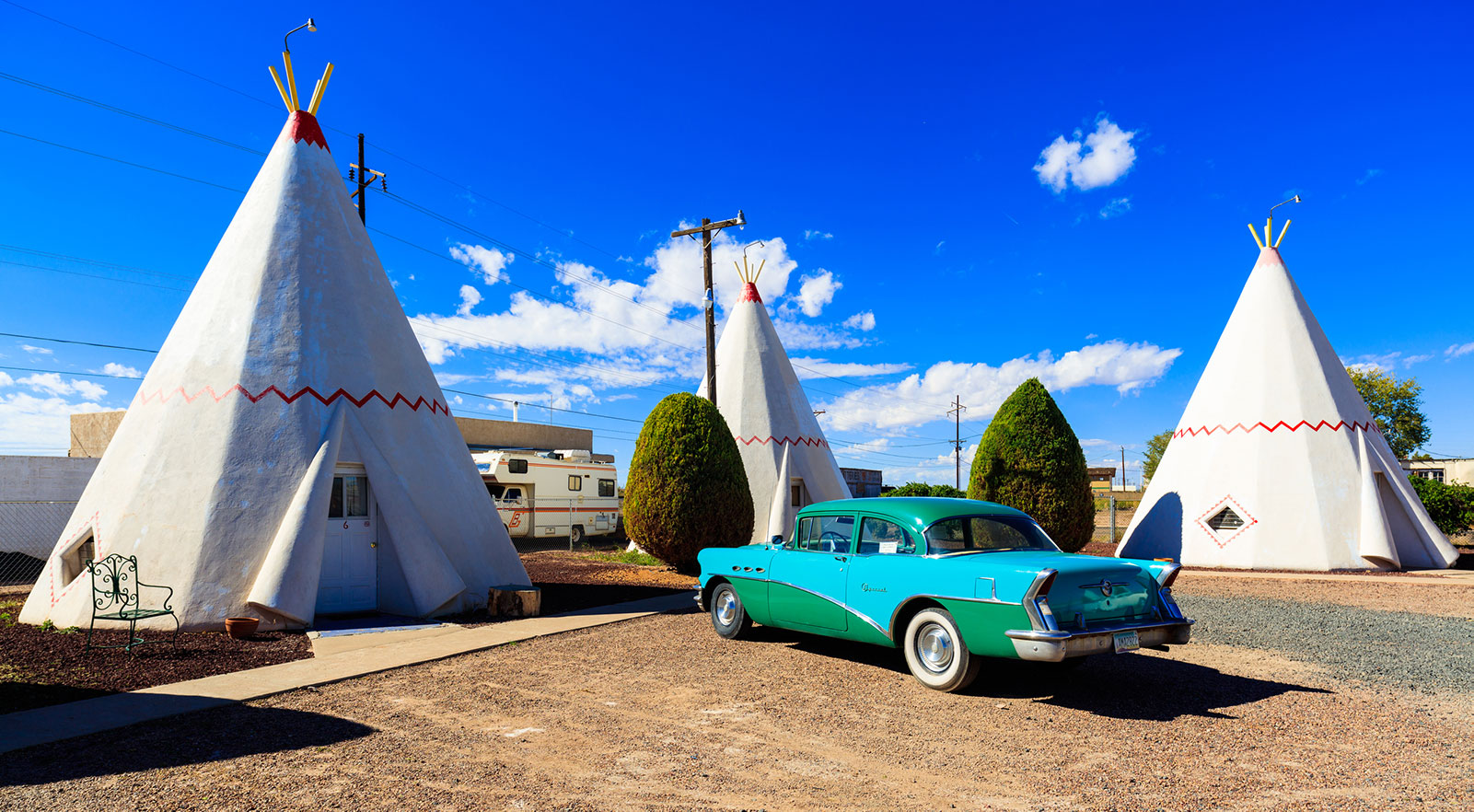 Classic car outside the teepee structures of the Wigwam Motel in Holbrook Arizona