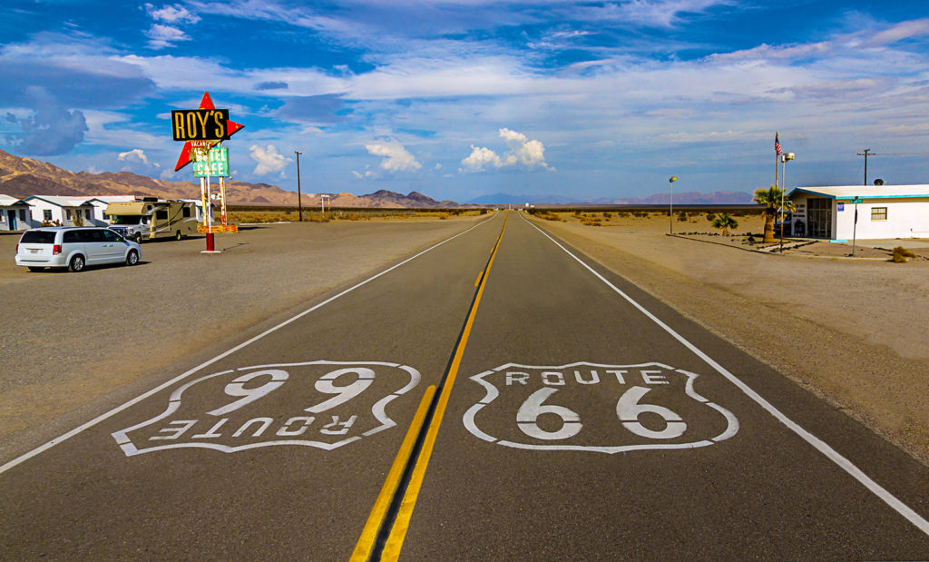 Route 66 markers painted on the road in front of the iconic Roy's Diner sign in Amboy, Cailfornia