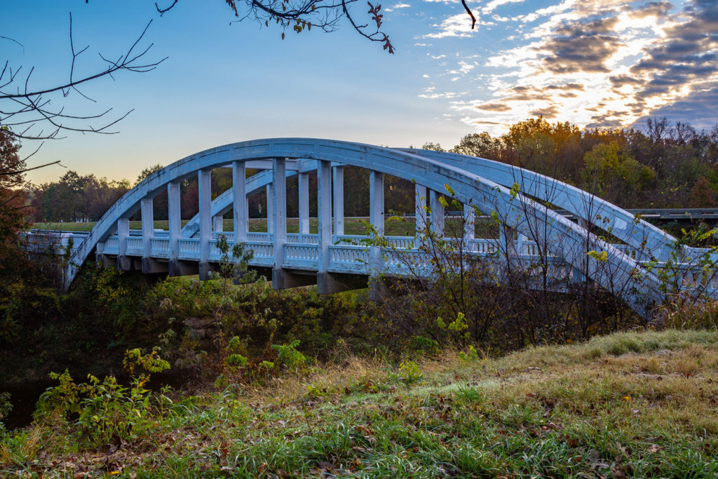 An arch bridge at morning with a grassy pastoral feel