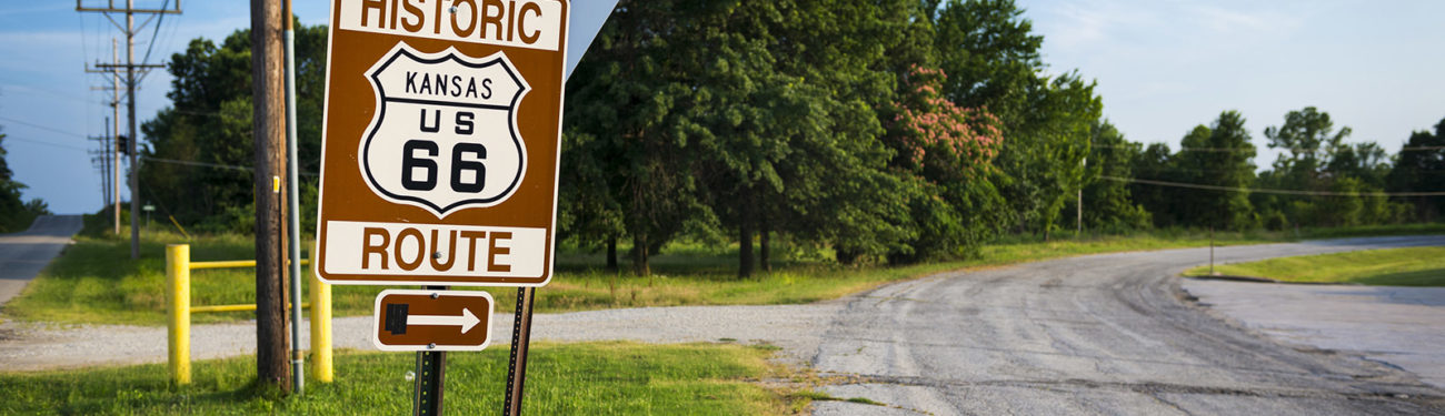 A historic Route 66 sign in Kansas posted at the side of the road.