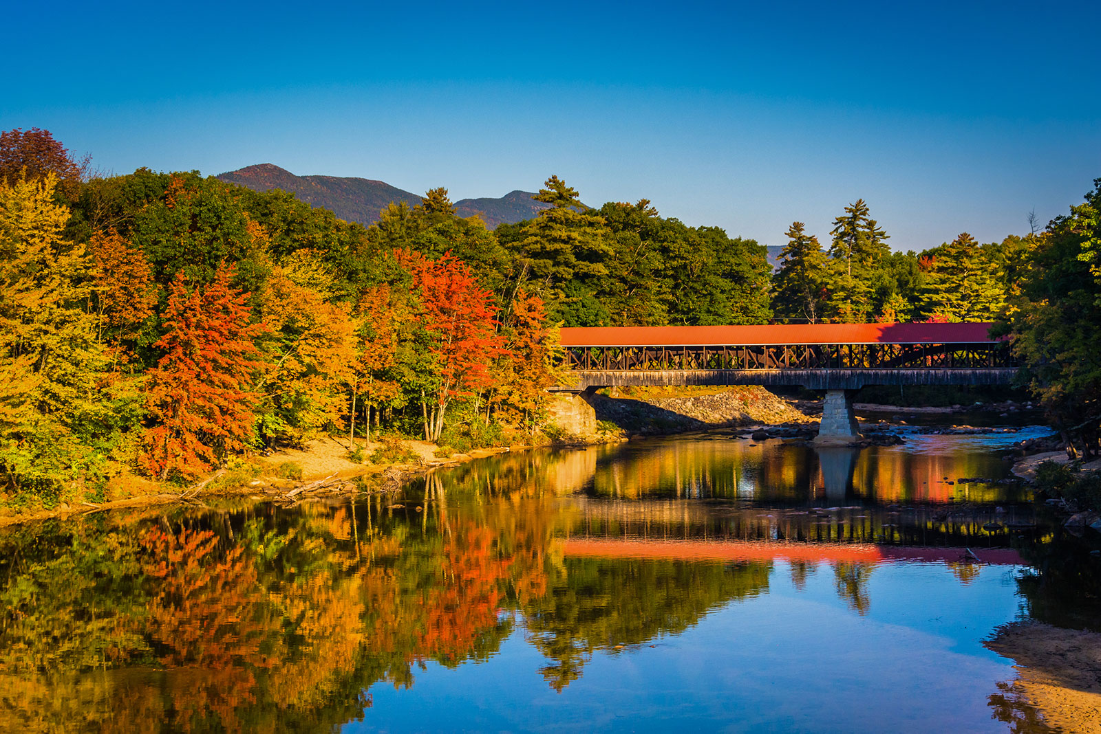 Looking across the Saco River in Fall at a covered bridge