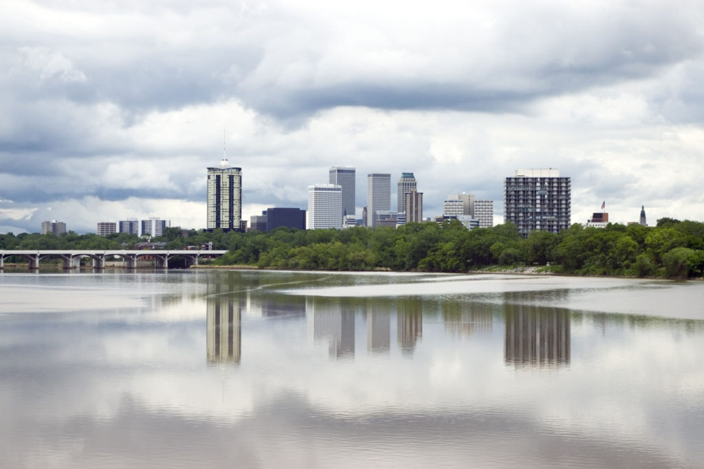 stormy skyline of the city of tulsa just before a severe spring storm, mirrored by its reflection in the arkansas river.