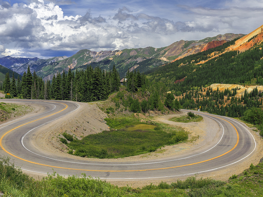 highway looping through trees and mountains