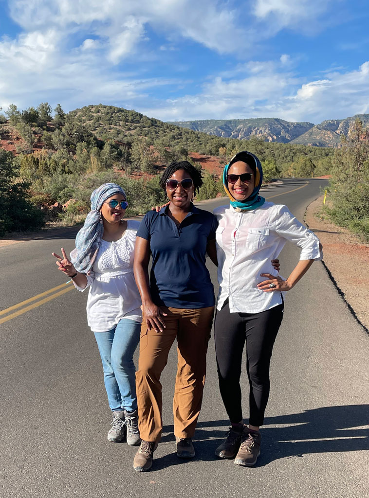 three women posing on a road in the southwest