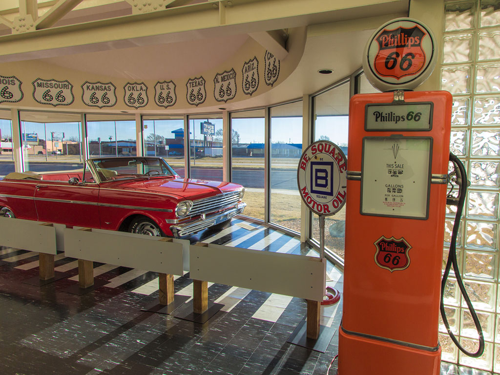 classic car and old gas pump inside a museum