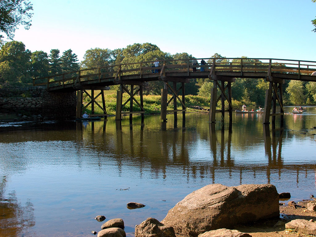 calm water under a wooden bridge in concord Massachusetts 