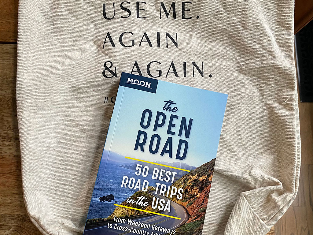 the open road travel guide on a canvas bag