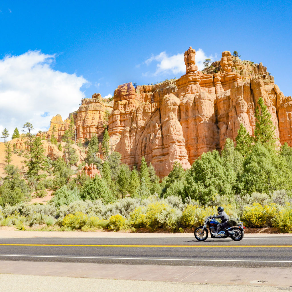 motorcyclist driving by hoodoos in bryce canyon