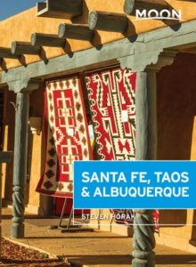 Cover of Moon Santa Fe Taos and Albuquerque Travel Guide with native rugs hanging in front of a shop.