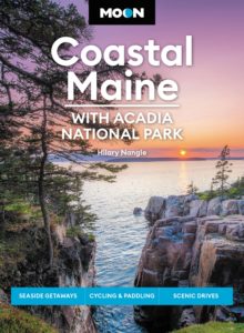 Book jacket of the Moon Coastal Maine travel guide featuring a picture of a vibrant sunset over rocky ocean cliffs